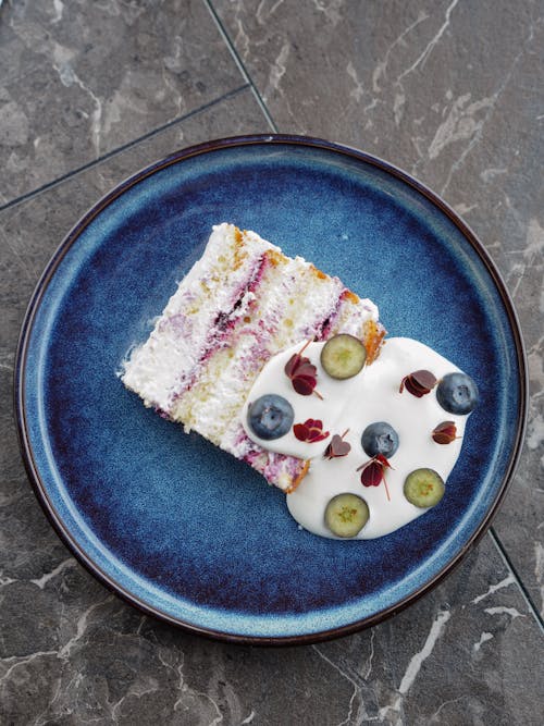 Free Slice of Cake with Yogurt on Blue Plate Stock Photo