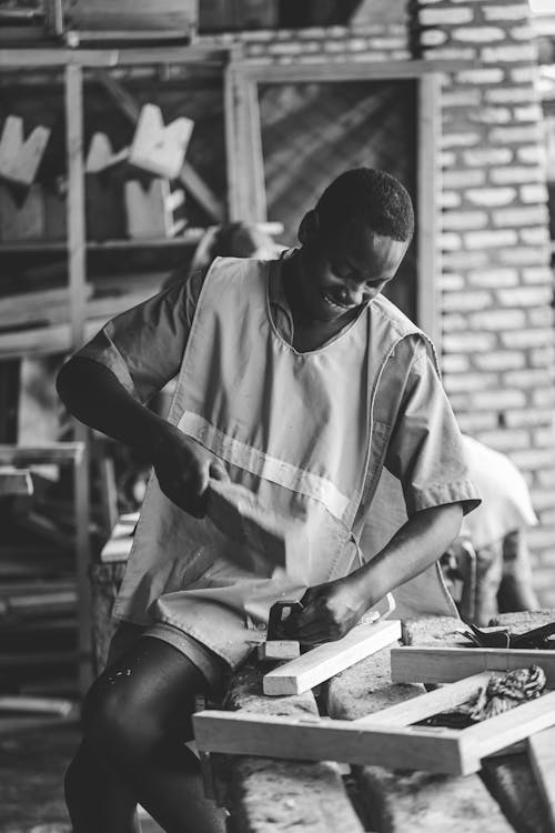 Young Man Working with Planks in a Workshop