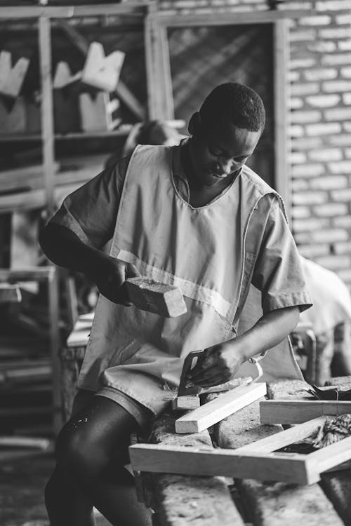 Man Working with Wood on Table in Black and White