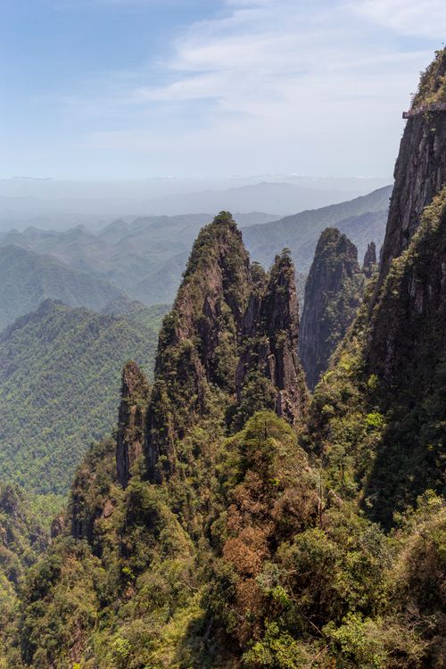 Free A breathtaking view of rugged mountain peaks surrounded by lush vegetation and misty horizons. Stock Photo