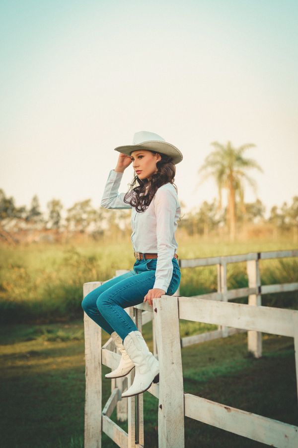 woman in straight-leg jeans and brown cowboy boots with a denim jacket
