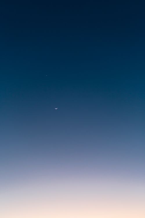 Free Minimalist image of crescent moon and star in twilight sky, showcasing serenity and beauty of dusk. Stock Photo