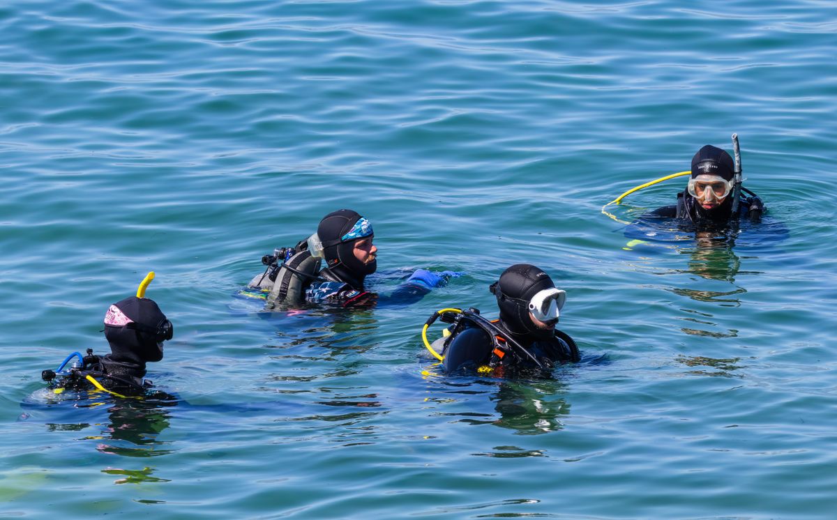 Group of scuba divers at the surface preparing to dive