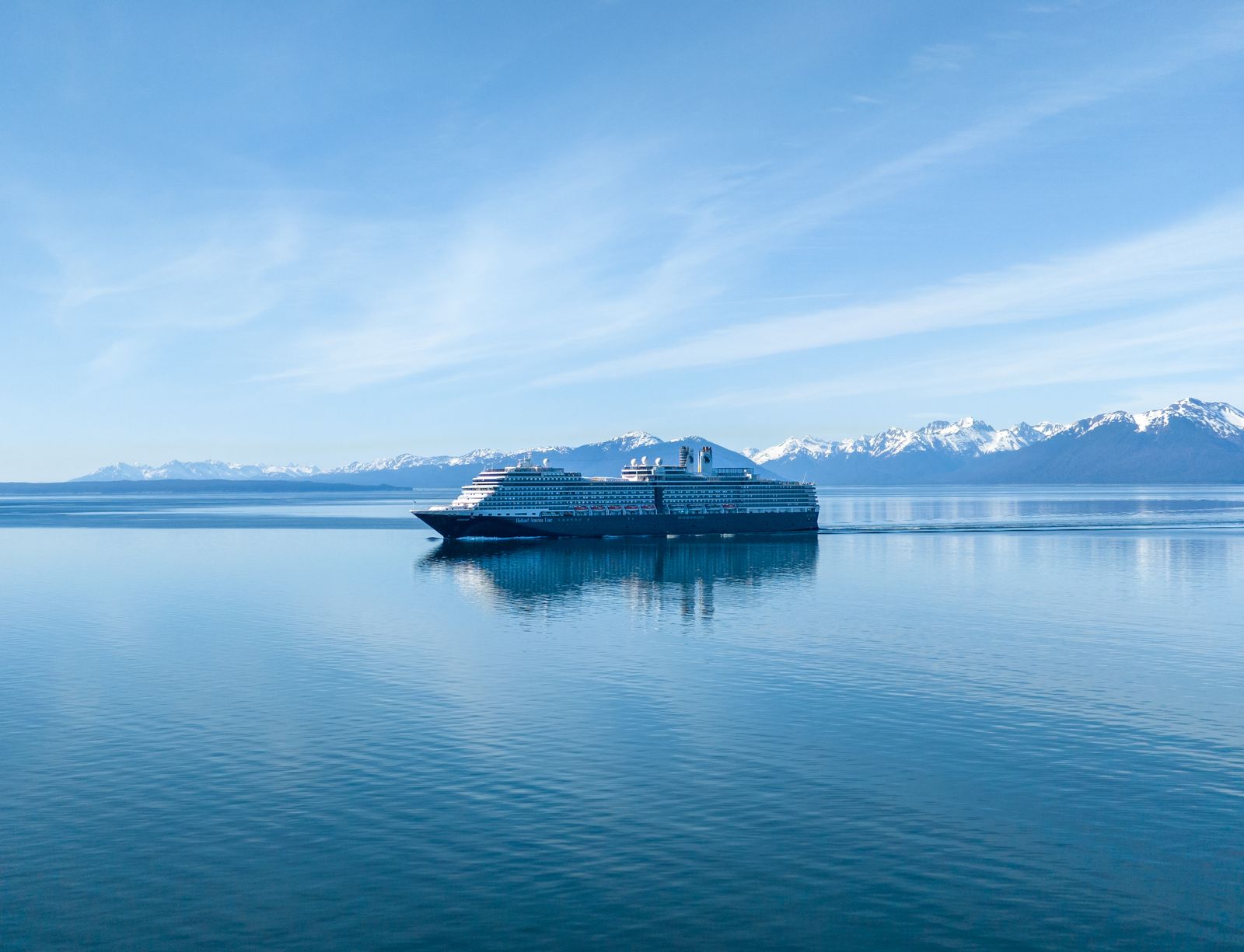 Cruise ship against the rugged coastal landscape of Alaska