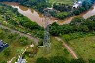 鸟瞰图中，郁郁葱葱的绿化和河流穿过印度尼西亚万丹新当查亚的电线