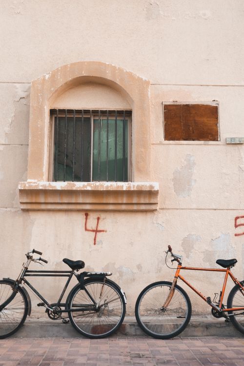 Free Two bicycles parked against a weathered wall in Dammam, Saudi Arabia, highlighting urban life. Stock Photo
