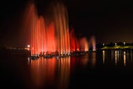夜间，五颜六色的灯光映照在水面上，呈现出令人惊叹的喷泉灯光秀