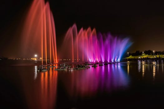 夜晚，城市河流上倒映着色彩缤纷的灯光，与充满活力的喷泉交相辉映