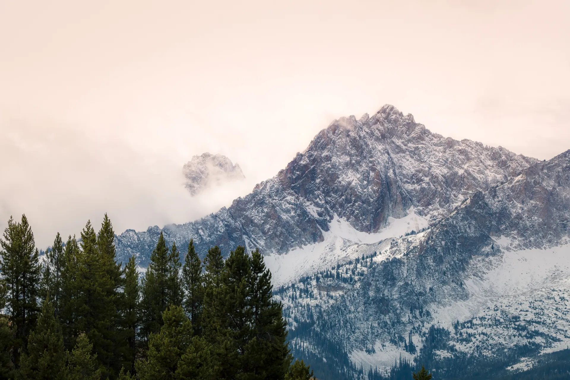 Breathtaking view of snow-covered mountains with evergreen trees in Stanley, Idaho.