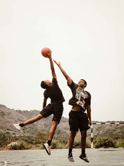 Men Midair while Playing Basketball