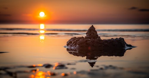 無料 ゴールデンアワーの海岸の砂の城 写真素材