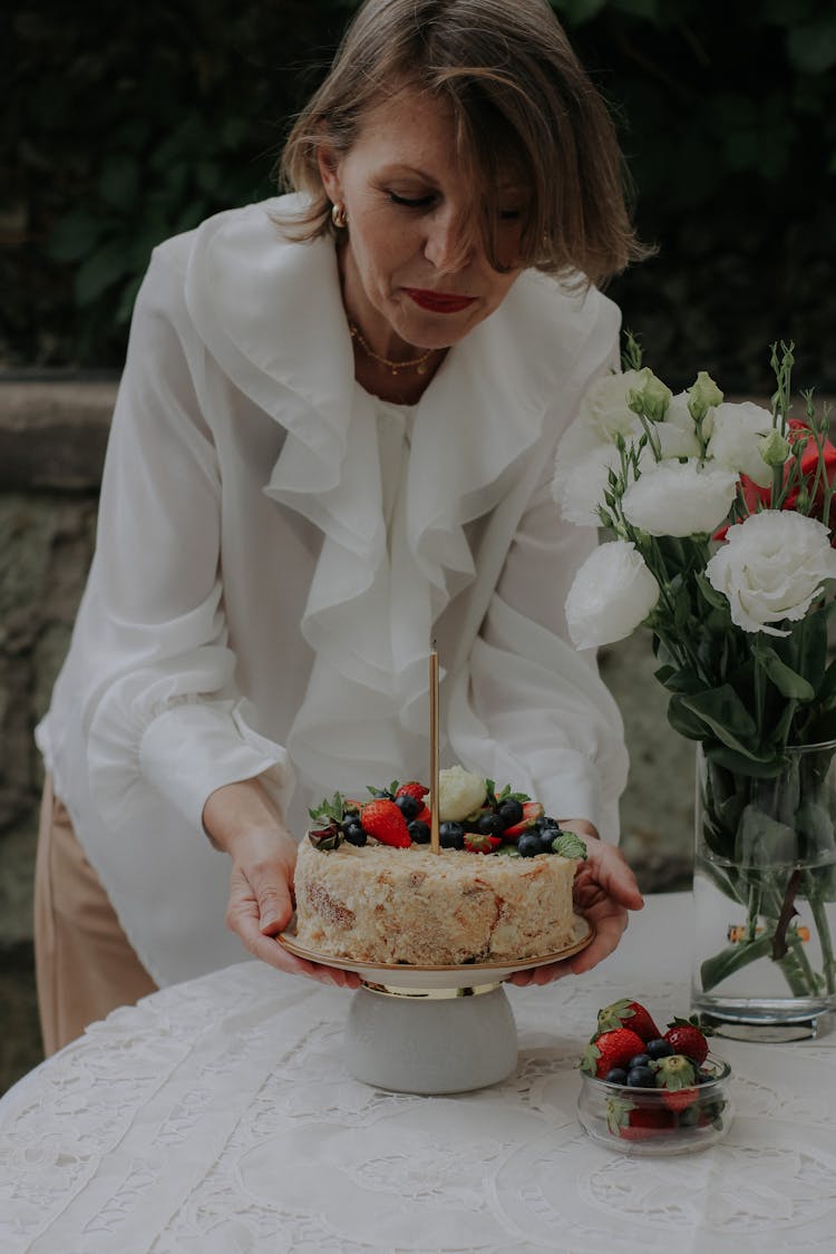 Woman Picking Up A Cake From A Table