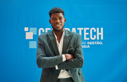 Free Businessman in suit smiling confidently with arms crossed at a technology event. Stock Photo