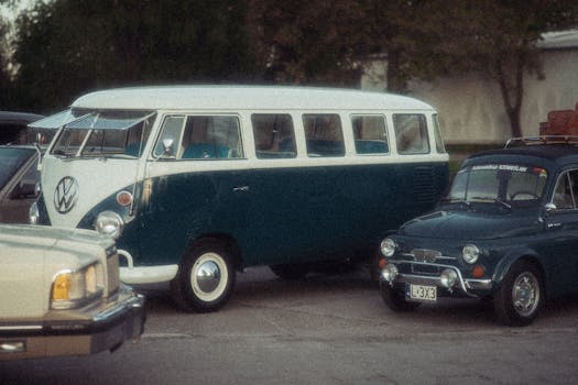 A classic Volkswagen Type 2 and a Fiat 500 parked side by side, showcasing vintage automotive design.