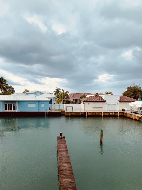 Free Scenic view of coastal homes by the waterfront in Antigua and Barbuda under an overcast sky. Stock Photo