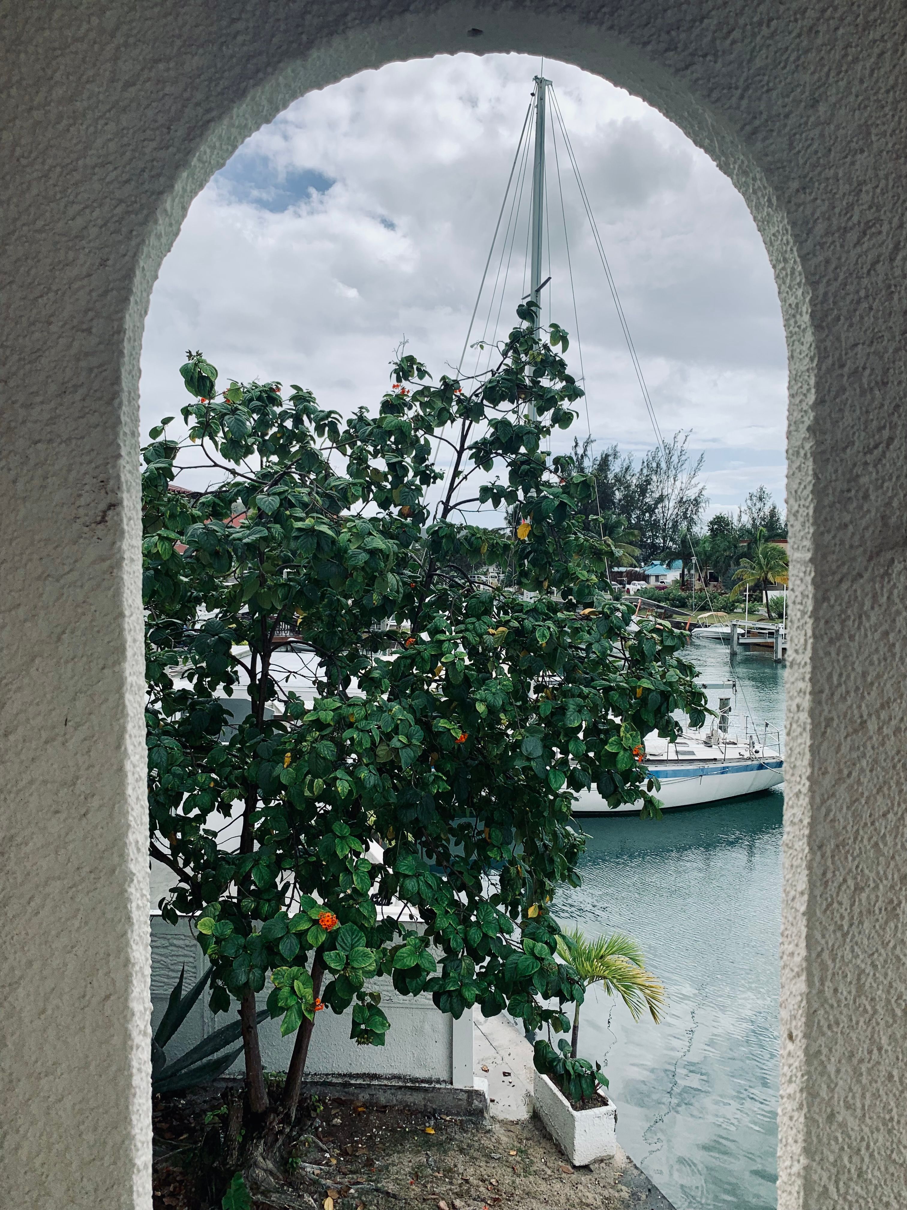 View of a sailboat through an archway with lush greenery in Antigua and Barbuda.