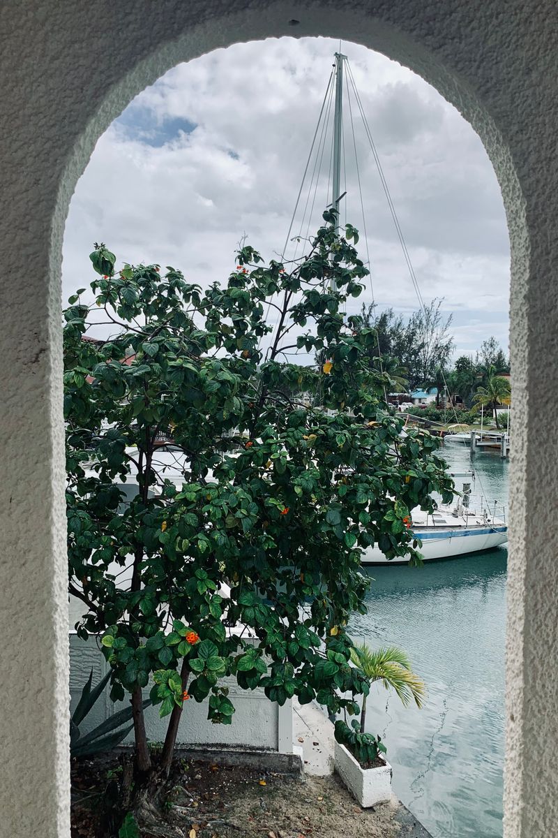 View of a sailboat through an archway with lush greenery in Antigua and Barbuda.