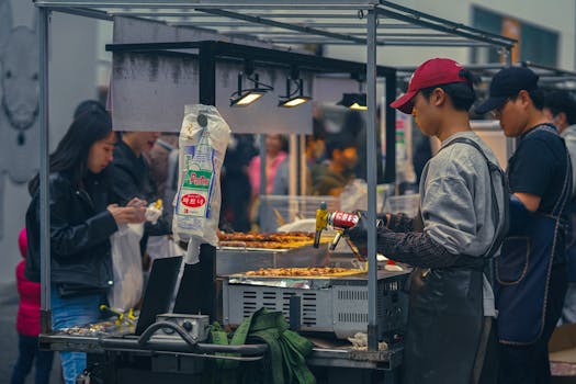 Vibrant street food scene at a bustling Seoul market, featuring vendors and diners.