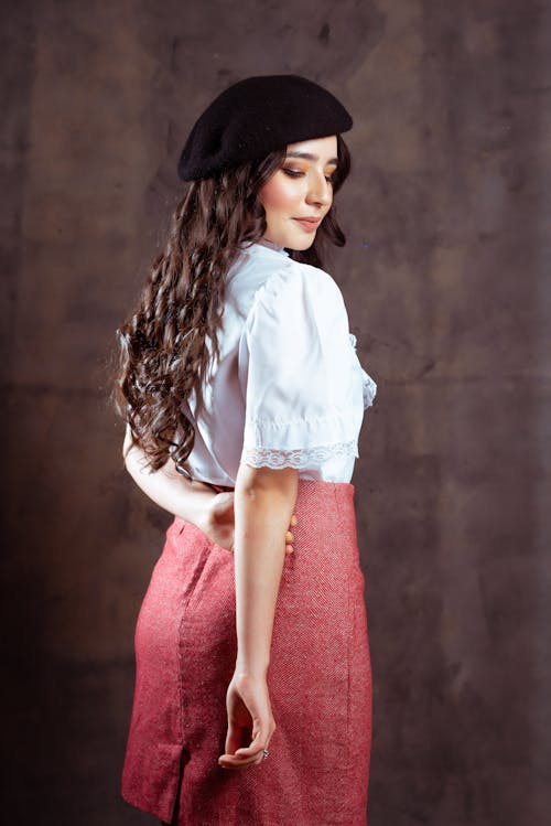 Woman in a Skirt, Blouse and a Beret Standing in a Studio