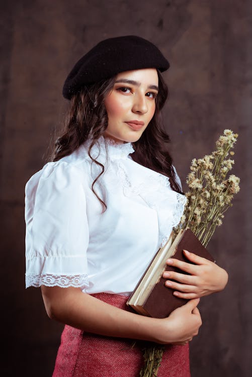 Woman in a Blouse and a Beret Holding a Bunch of Flowers · Free Stock Photo