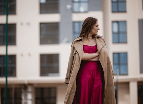 Woman in Pink Gown and Coat Standing under Office Building