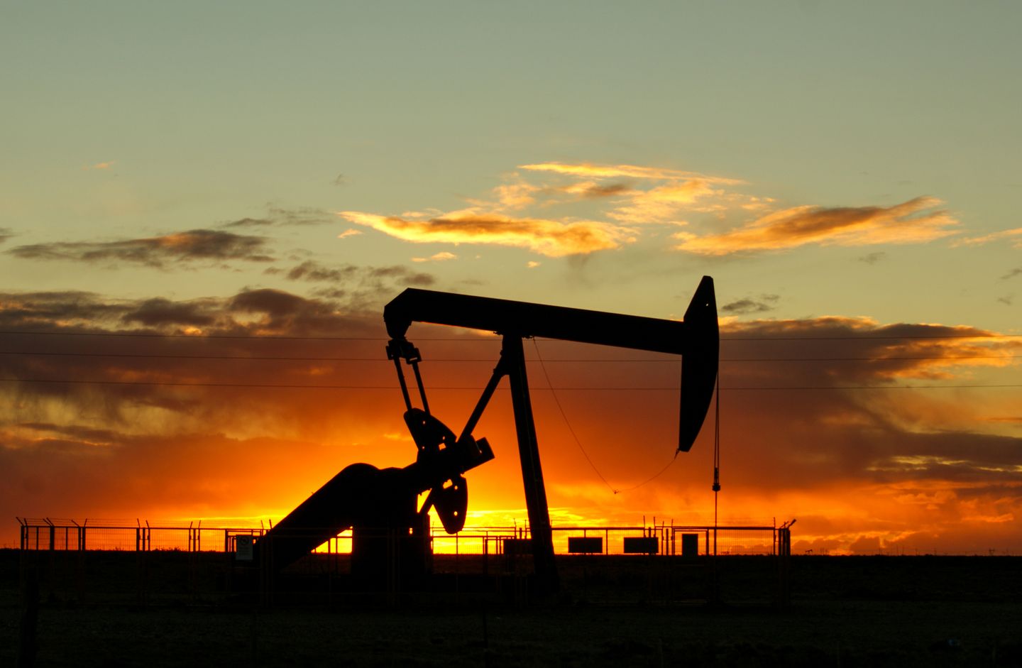 Representative photograph of an oil well silhouette at sunset for RecoupRev coverage: Brent vs WTI Oil: Why the Price Spread Changes and What Inventories Reveal