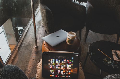 Free Modern cafe interior with tablets and coffee cup on table, perfect for tech and lifestyle themes. Stock Photo
