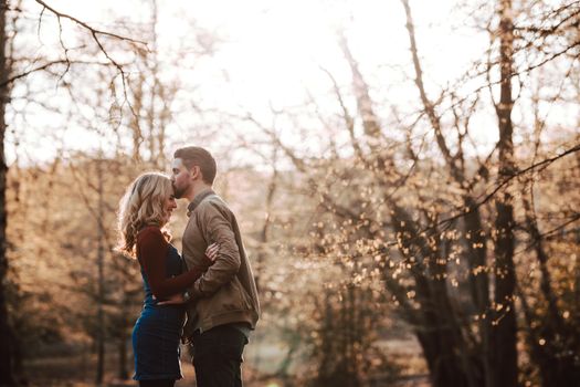 Romantic Boho Engagement Photoshoot of couple in the Woods kiss on the forehead