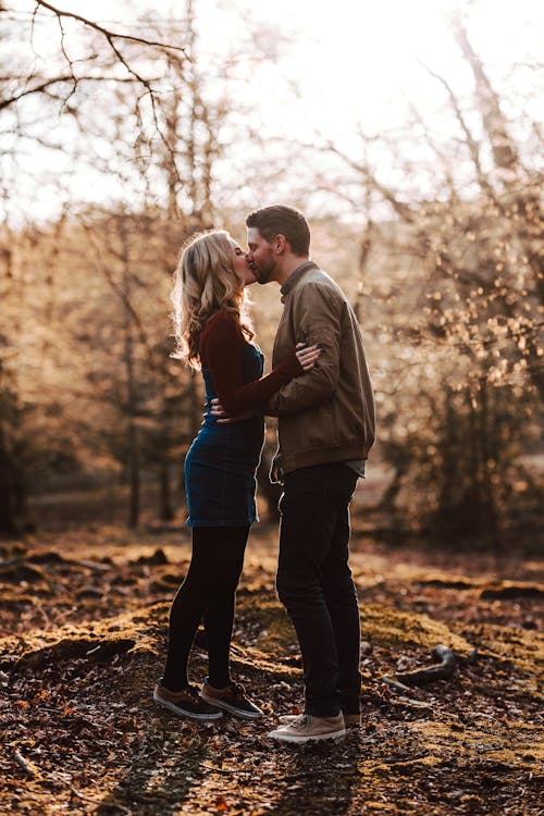 森の中でキスするカップルのロマンチックな自由奔放に生きる婚約写真撮影
