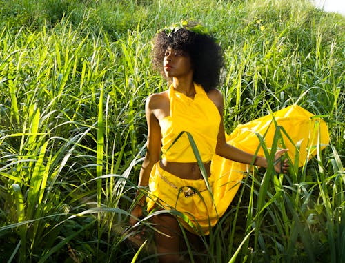 Woman In Yellow Dress Standing In The Middle Of Tall Grass