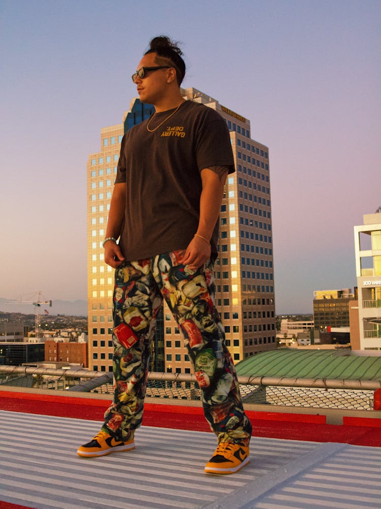 Young Man In A Casual Outfit Standing On A Building Roof 