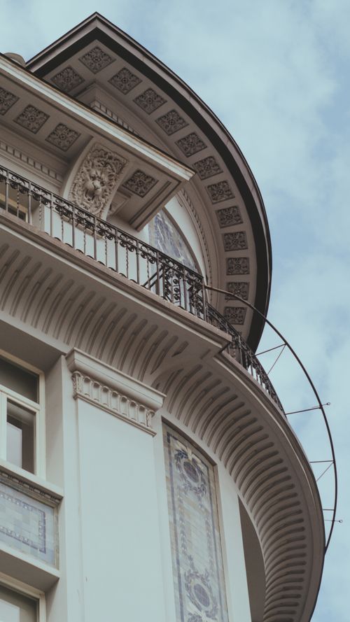 Free Elegant urban building with intricate architectural details and decorative balcony in a low angle shot. Stock Photo