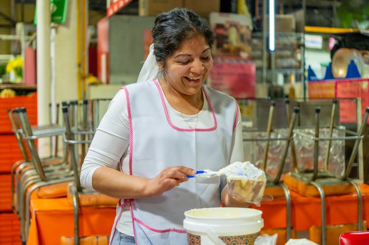 Smiling Woman In Apron Working In Kitchen