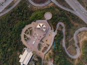 鸟瞰图令人惊叹，展示了一座被充满活力的绿色植物和蜿蜒道路环绕的现代建筑群