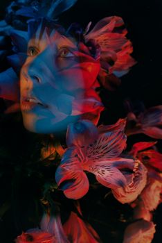 Surreal portrait blending human features with colorful floral elements.