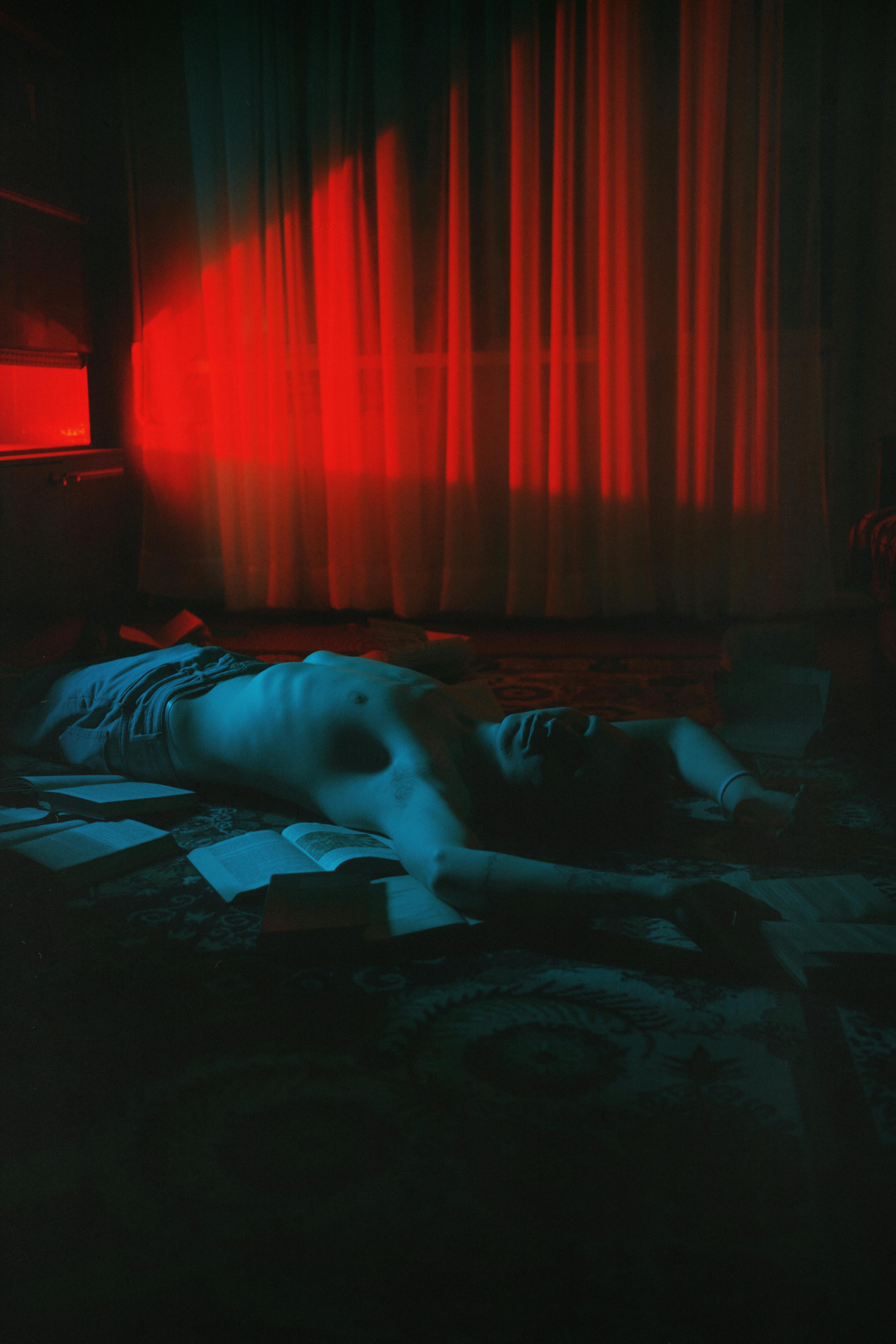 Topless Man Lying Down in Darkness · Free Stock Photo