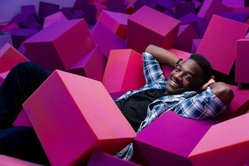 Smilnig Man Lying Down among Pink Blocks