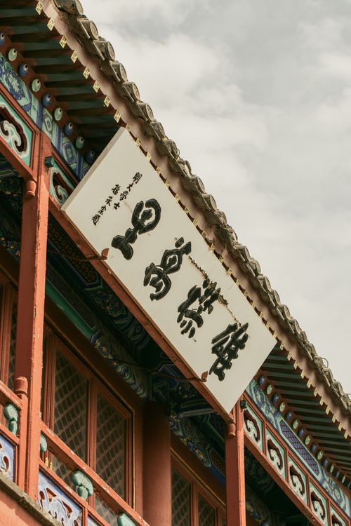 Free A detailed view of traditional Chinese architecture with ornate decorations and a prominent sign. Stock Photo