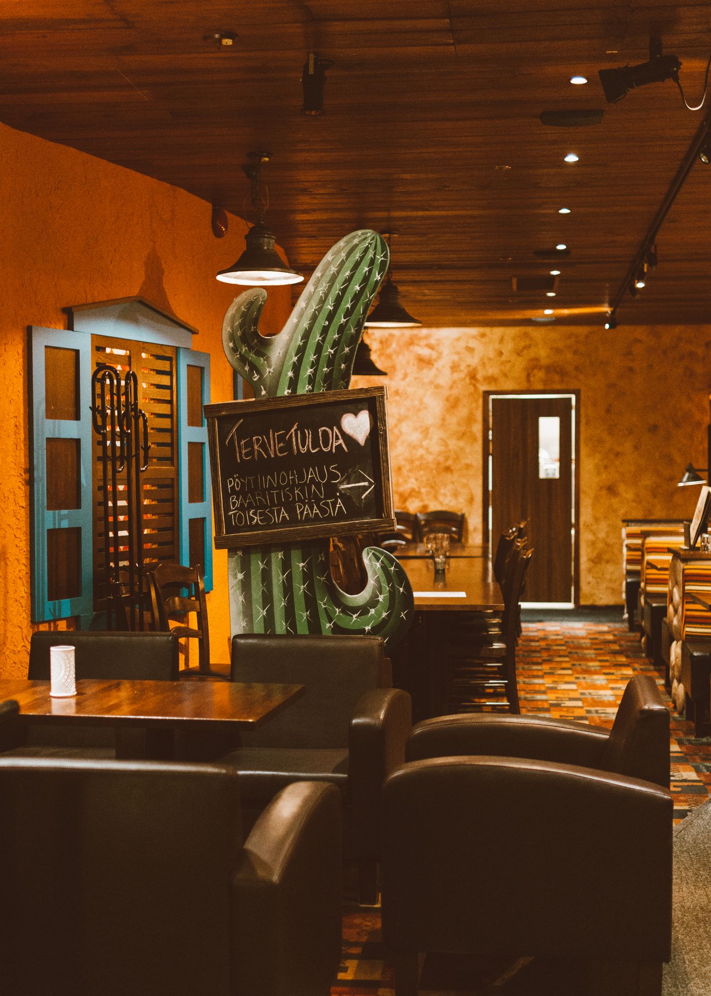 Warm Mexican restaurant interior with cactus decor, colorful walls, and cozy seating.