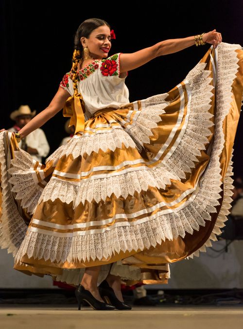 Free Colorful traditional dance performance by a woman in vibrant attire on stage. Stock Photo