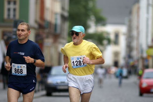 Two male runners participating in a city marathon race; showcasing endurance and fitness.