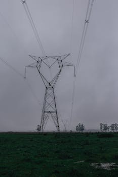 一座高大的输电塔矗立在雾中，捕捉到了工业与自然的本质