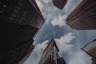 从低角度仰望，城市摩天大楼高耸入阴沉的天空