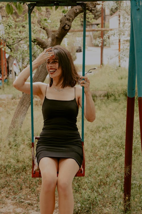 Smiling Woman Sitting on Swing