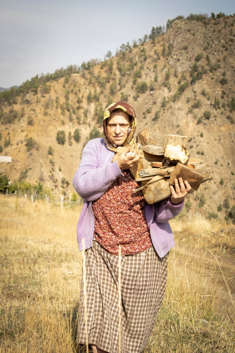 Elderly Woman Carrying Wood