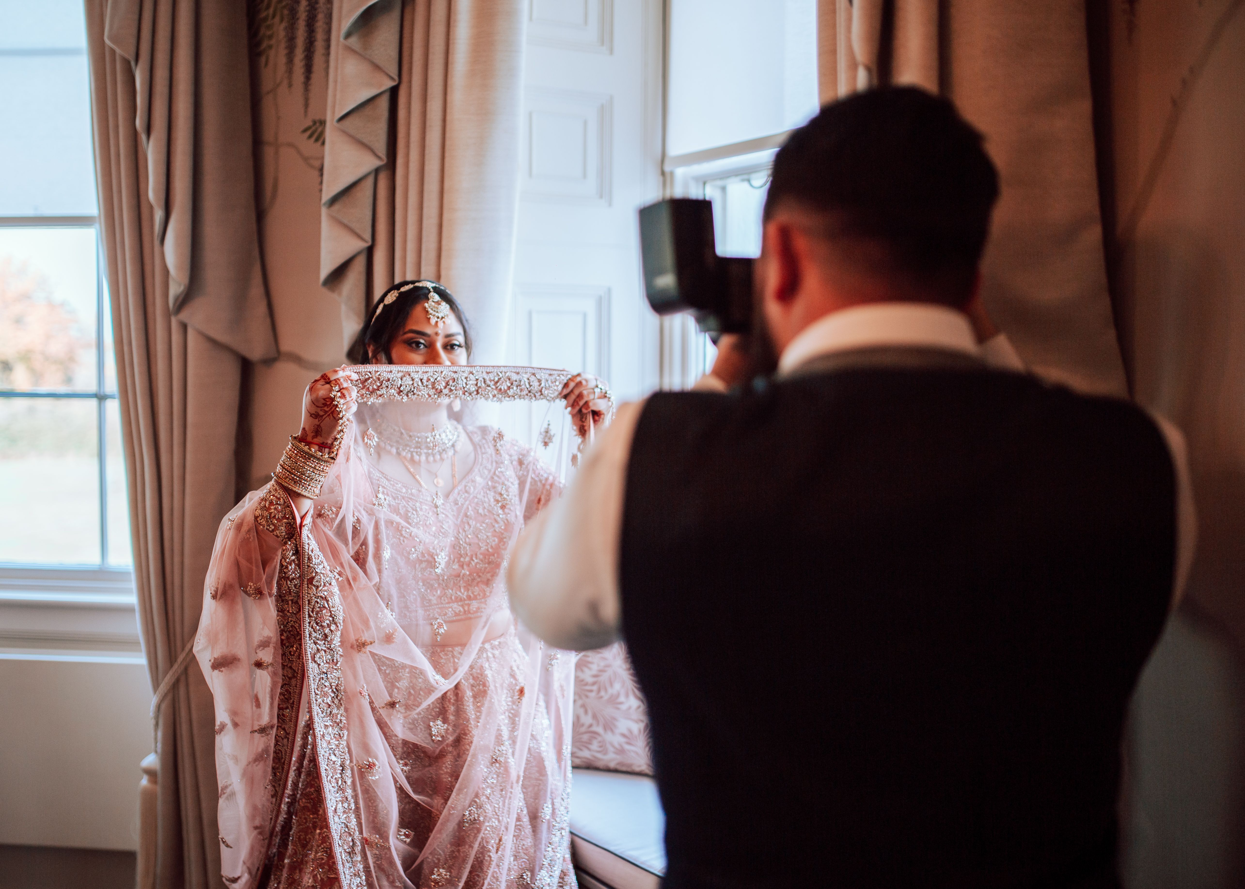 Wedding photographer capturing bride in traditional attire