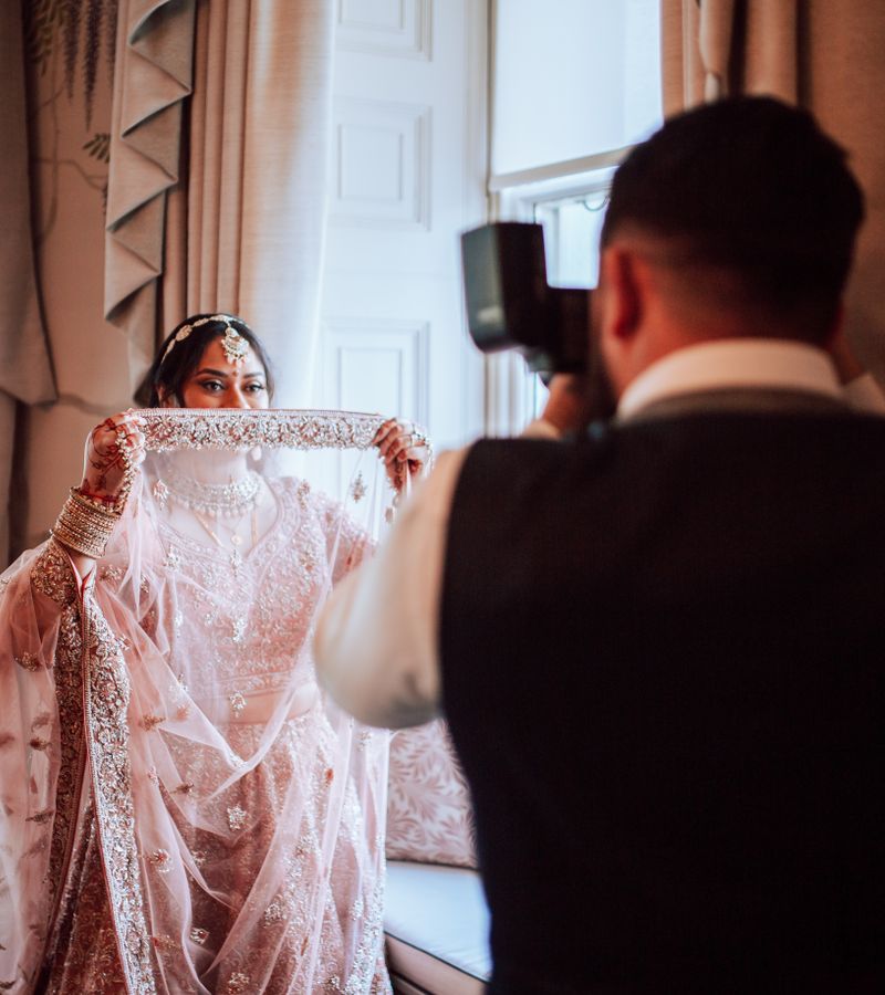Wedding photographer capturing bride in traditional attire