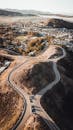 航拍照片展示了蜿蜒的道路和环绕着山丘与树木的城市景观