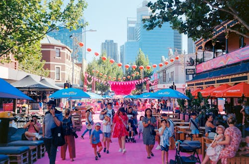 A pink street with people walking and eating