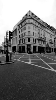 Monochrome image of city street with architecture and crosswalk.